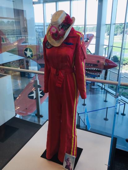 Vibrant flight suit with a cowboy hat, displayed in a museum