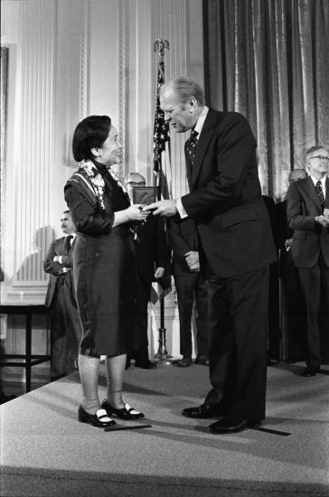 Photograph of Gerald Ford handing a woman an award.