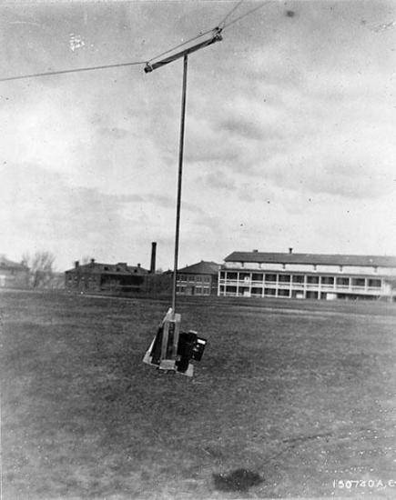 A camera hangs from a wire, elevated off the ground.