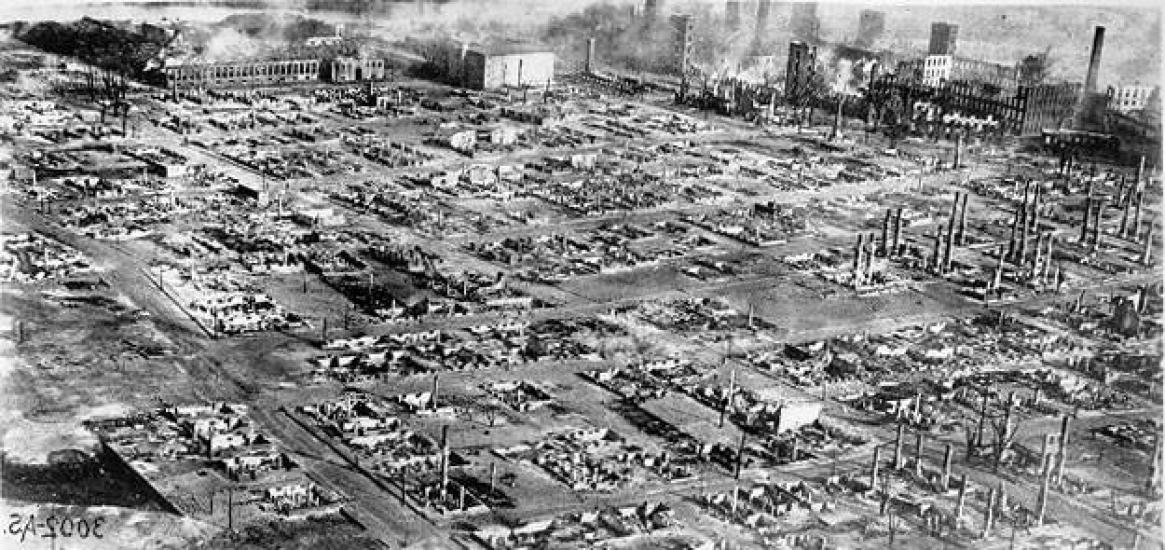 An aerial photo of a cityscape that has been razed almost entirely to the ground. 