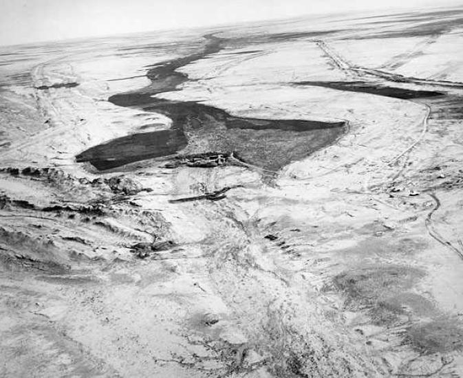 An aerial photo of a once used dam and died out canals around it.