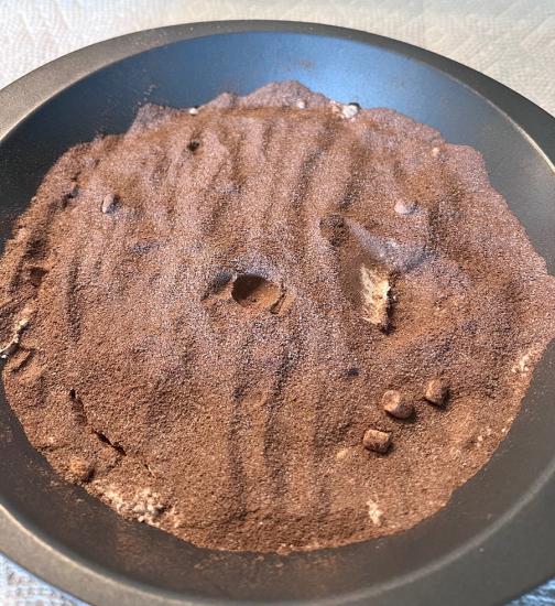 Brown flour-like substance in a silver bowl. There's a divet in the center. 