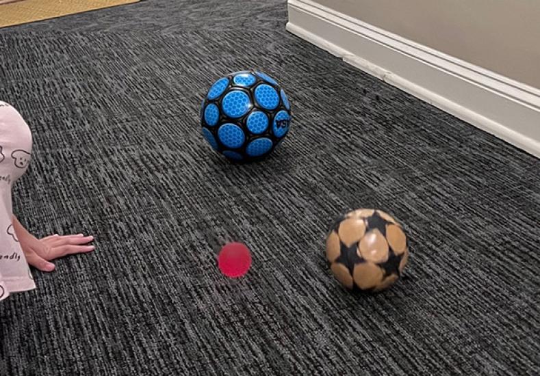 Three balls sit in a hallway.