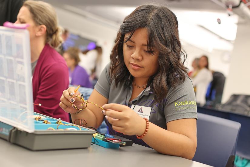 An educator looks at a piece of rope or wire. 