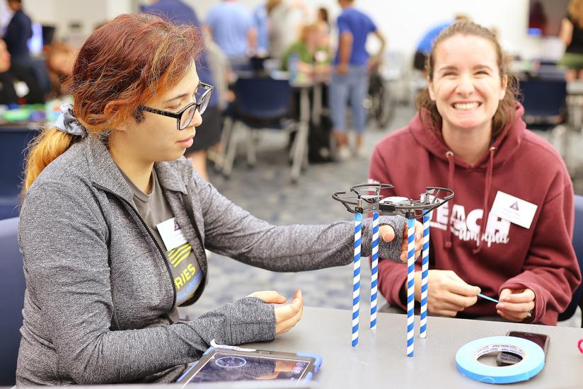 Two educators sit at a table working on a task. 