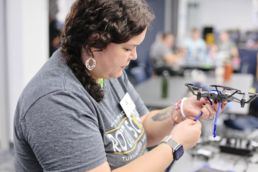 An educator appears to make a small hovercraft or drone. 