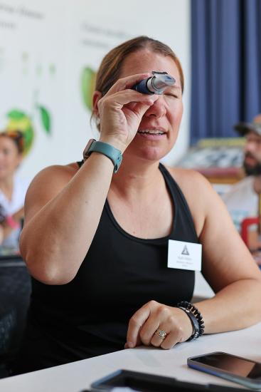 An educator looks into a tube. 