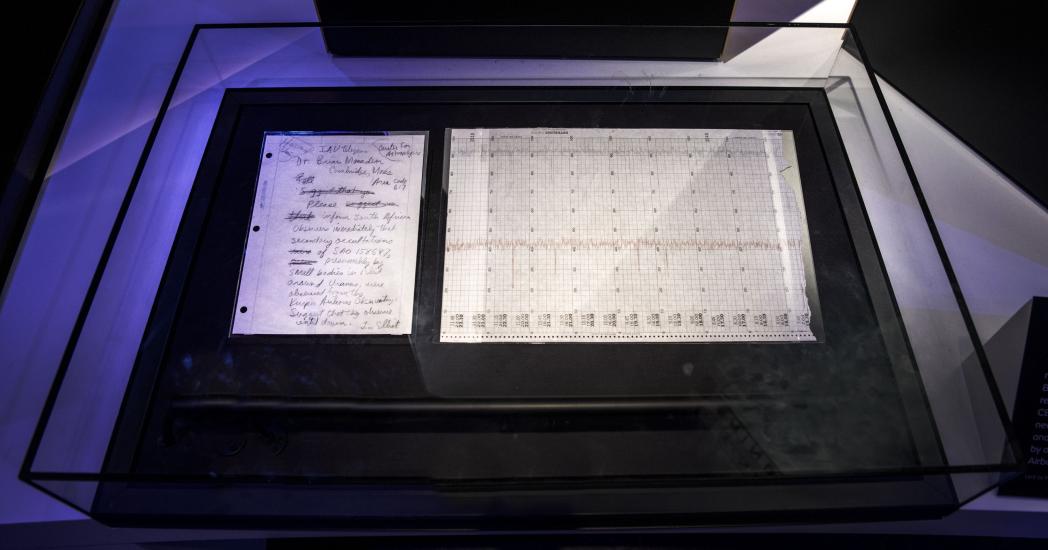 A handwritten letter describing the discovery of rings around Uranus next to a chart demonstrating the discovery. Both are in a display case.