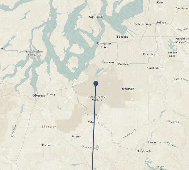 A map showing the areas of Tacoma and Olympia, Washington. A blue dot marks Fort Lewis, toward the center of the map.