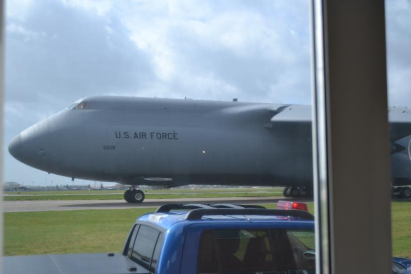 Closeup of a large aircraft as it taxis on a runway.