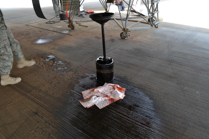 A device is on top of oil on a pavement.