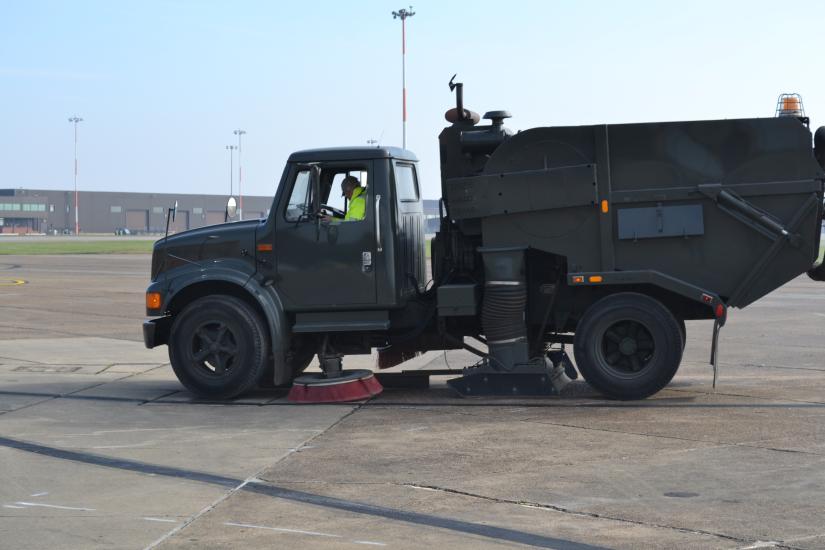 A truck sweeps on a runway.