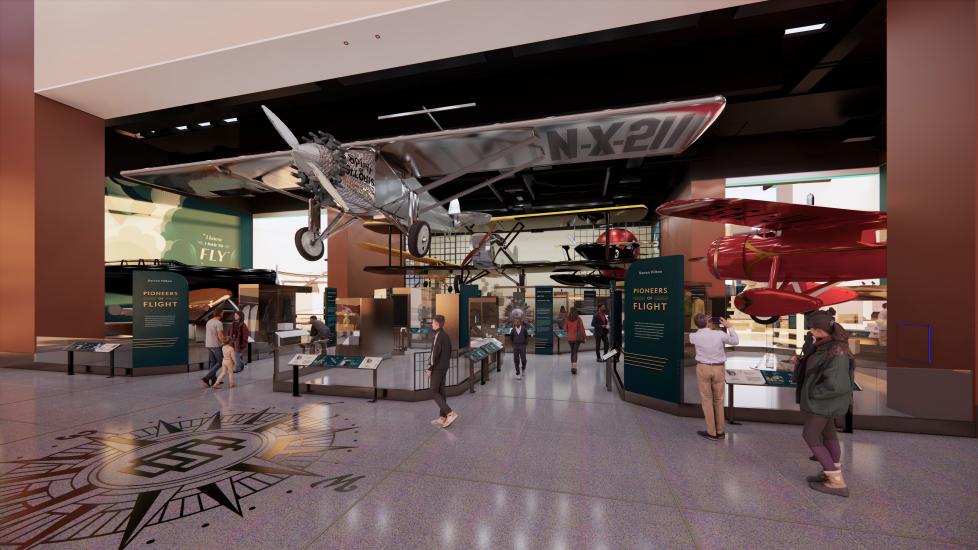 An artist's concept of the Barron Hilton Pioneers of Flight exhibition. In the center is a hanging silver airplane, a red airplane peaks out of the right. There are vertical panels with information on it.