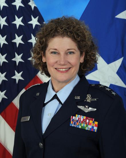 A woman in military uniform smiles for a portrait.