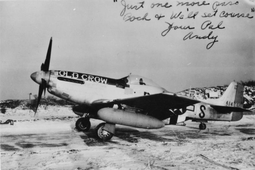 Vintage photo of the "Old Crow," a World War II military aircraft parked on a sandy area. Cursive writing across the top reads, "Just one more pass, Good luck & we'll set course - Your Pal Andy."