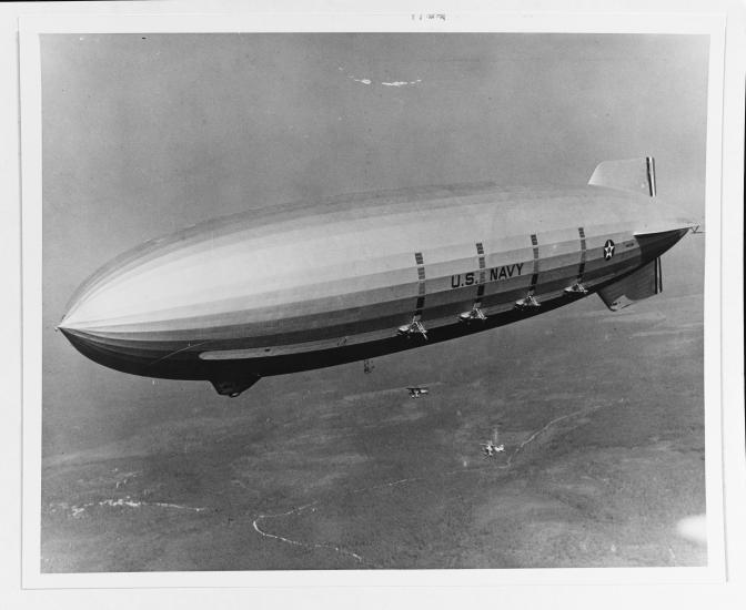 Large airship flies over land.