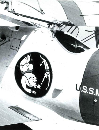 Insignia on the side of a aircraft that shows two people during a trapeze act.