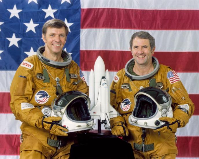 Two astronauts pose for their official NASA portraits.