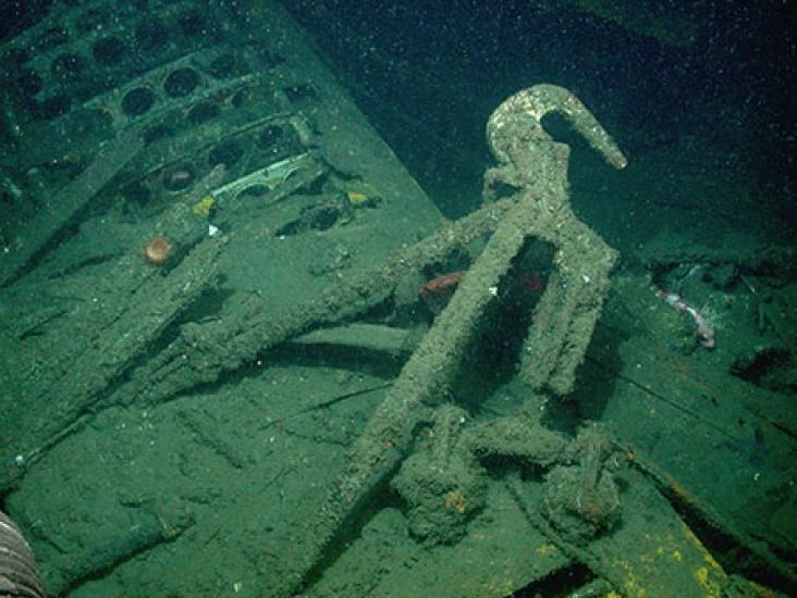 A hook connected to a piece of a wrecked airship underwater.