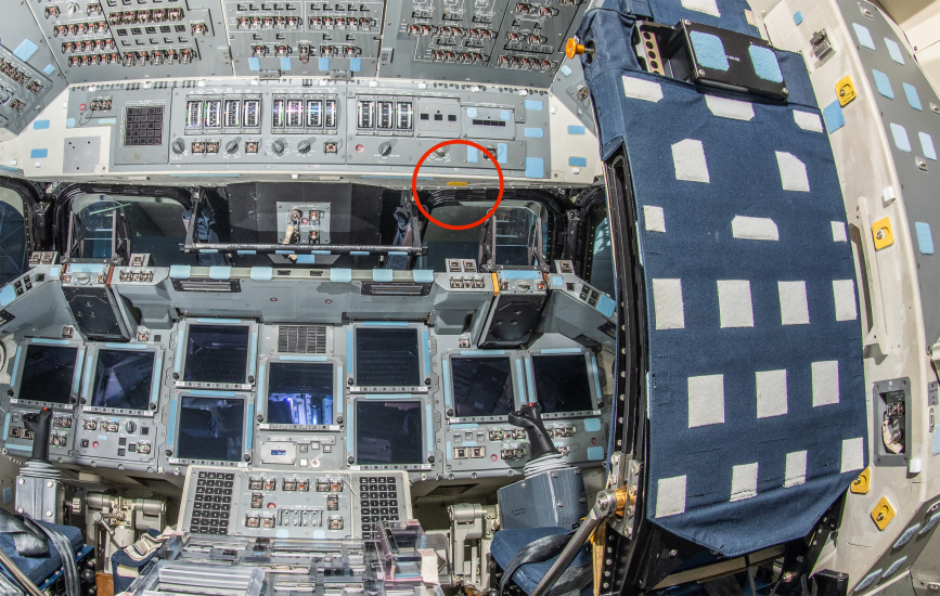 The interior cockpit of a space shuttle, featuring an array of control panels with numerous switches, buttons, and screens, highlighting the intricate operations required to pilot such a craft.