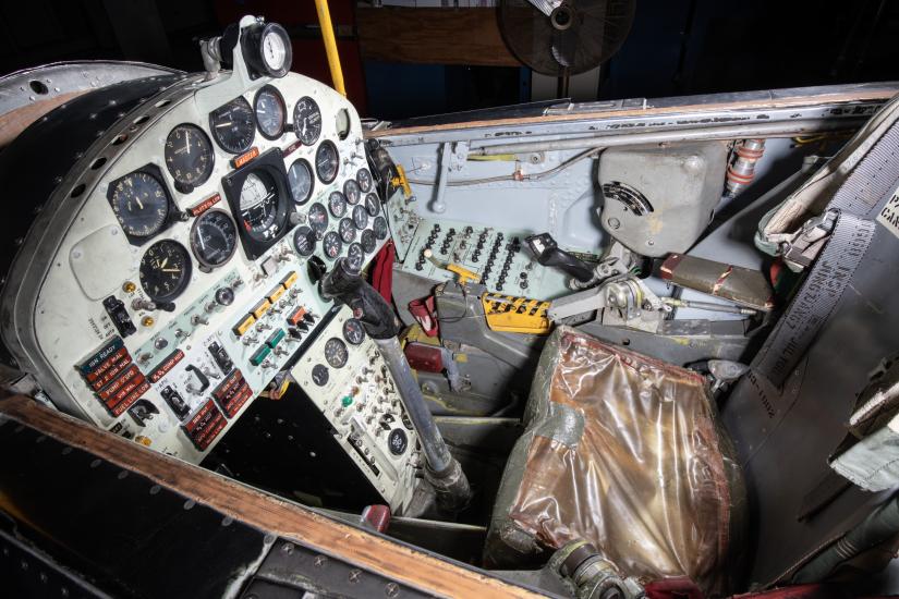 Detailed view of the cockpit of a vintage aircraft, featuring an array of dials, switches, and controls.