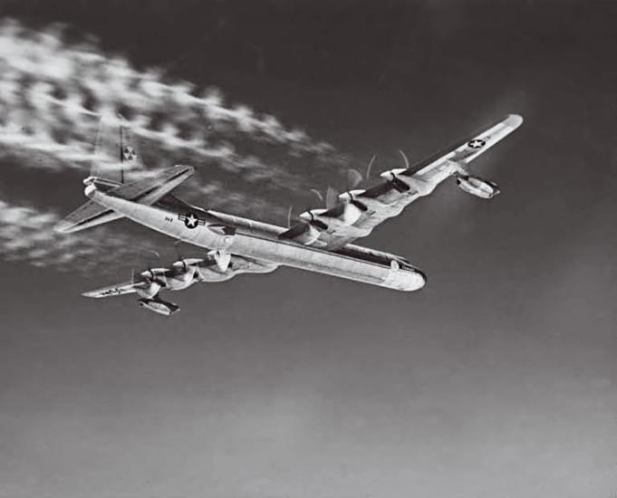 A low-angle view of six prop aircraft is shown in this black and white photo.