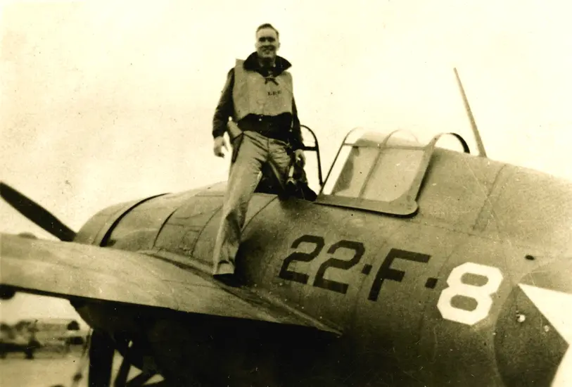 Person standing on the wing of a vintage military aircraft marked with '22 F 8'.