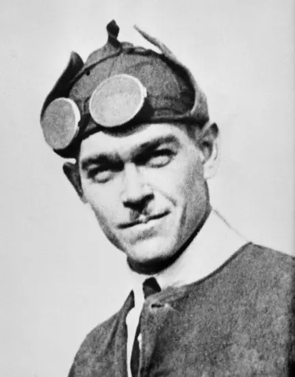 Portrait of Ormer Locklear as he wears a dark jacket and a hat with goggles strapped to his forehead. 