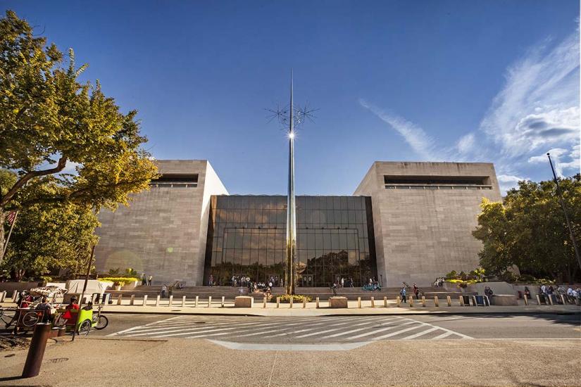 View of the front entrance and large narrow sculpture of the National Air and Space Museum's building in Washington, D.C.