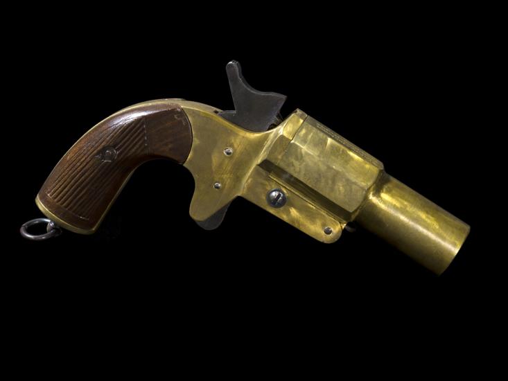 Side view of a yellow painted flare pistol.