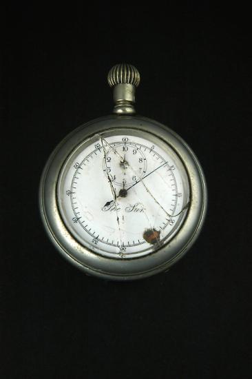 Broken stopwatch with hand pointed at nine-minute mark. 