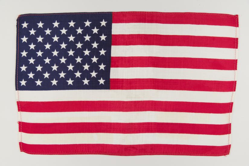 American flag unfolded against white backdrop.