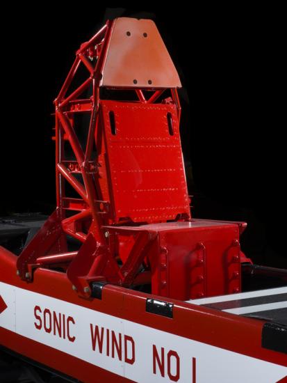 Straight metal seat attached to the middle of a rocket sled. Sonic Wild No 1 is painted on the vehicle. 