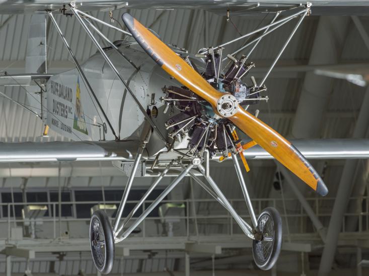 Propellers and fuselage of a biplane. The biplane is hanging in the museum.