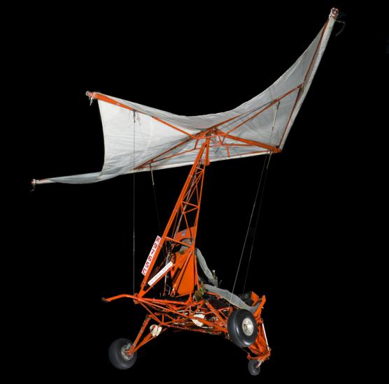 Small one-man glider made of steel tubing with 3 tires and parasail.