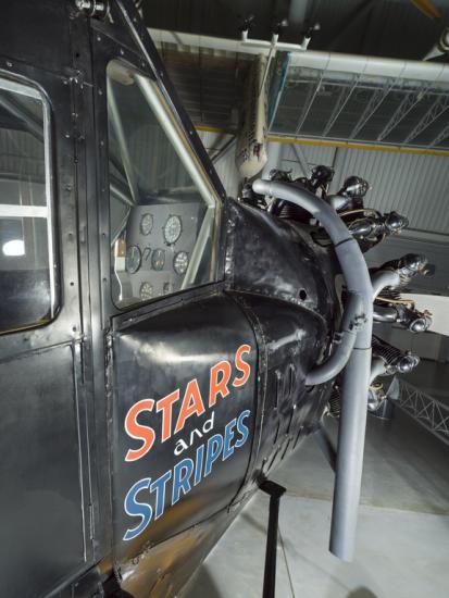 View of the cockpit and engine of an airplane. The words Stars and Stripes are painted on the side of the airplane.