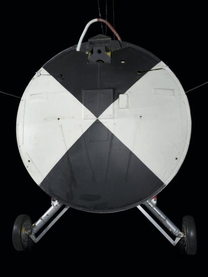 Painted black and white heatshield with wheels attached to the vehicle. 