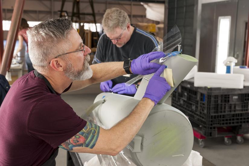 Bill George marks windows on the secondary hull of the Enterprise model. 