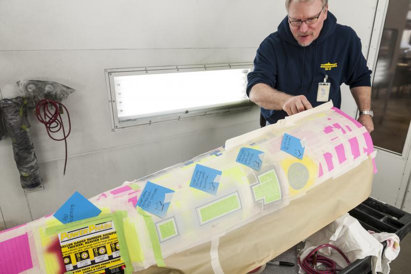 Post-it notes and masking tape create an outline on the model's secondary hull. 