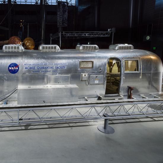 A silver trailer with the text "Mobile Quarantine Facility" on the exterior