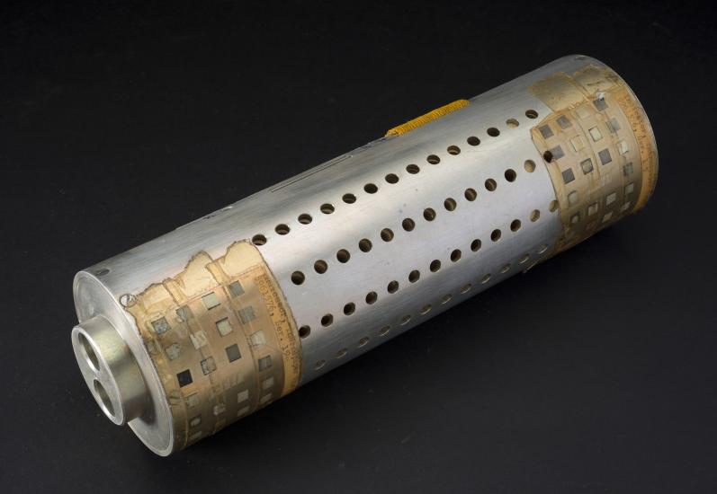 Metal cylindrical Primate Cradle with small circular holes and tape on edges