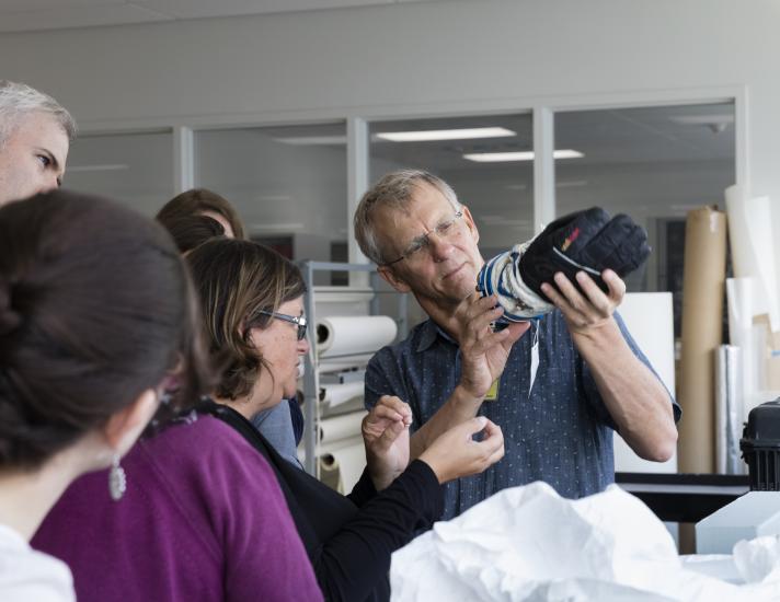 Alan Eustace, a record-holding altitude jumper, holds and inspects the glove of the suit he wore during his record breaking jump.