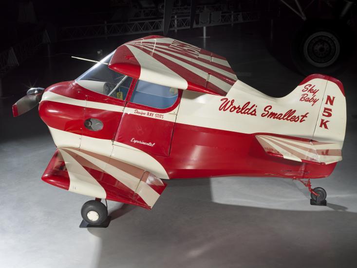 Side view of red and white painted smallest man-carrying plane. 