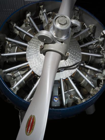 Close up view of a propeller attached to an engine of a plane.