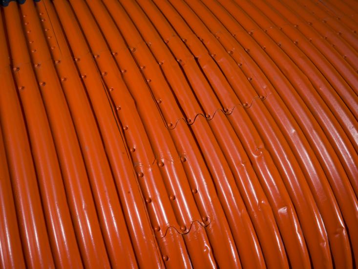 Close up image of an orange wing of a plane.