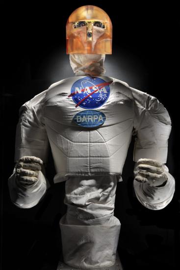 Frontal view of a body of a robot with arms, chest with a NASA logo, and an orange face cover.