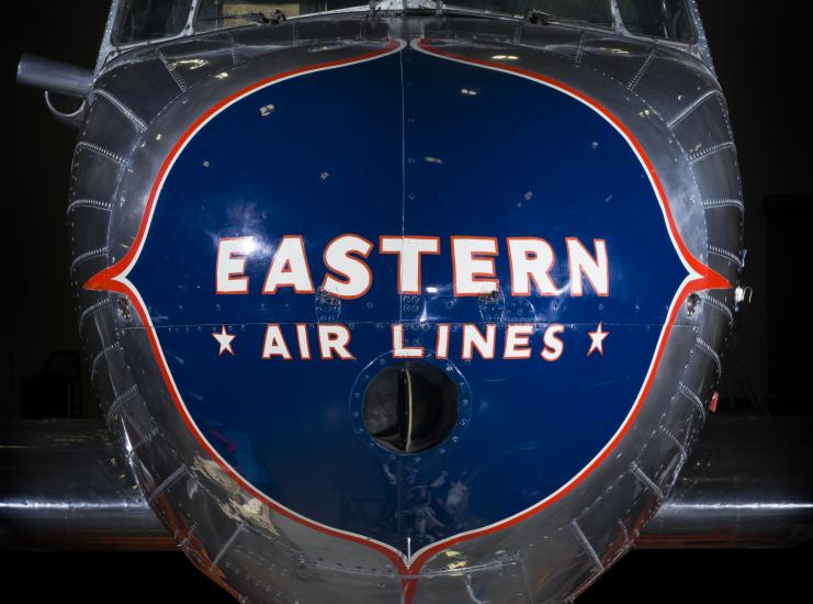 Close up of the nose of the plane. Painted on a blue nose is the phrase "Eastern *Air Lines."