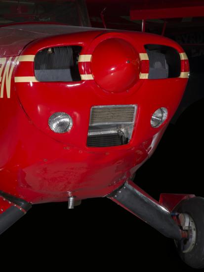 Close up of the nose of a red pained plane. 