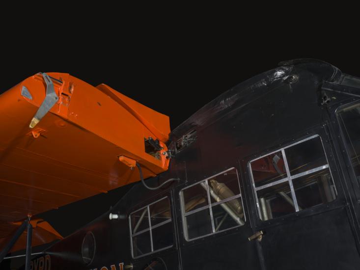 Orange wings and black painted fuselage of an airplane.