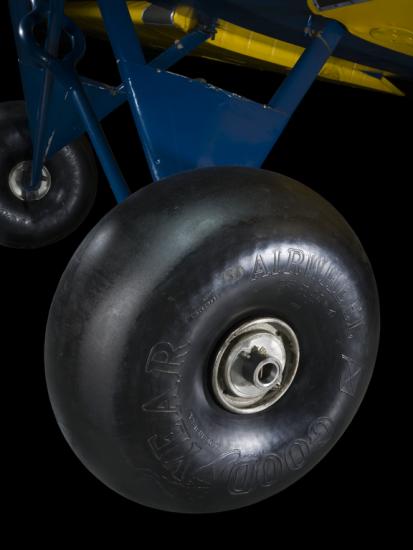 Close of of a tire and blue painted landing gear of a airplane. 